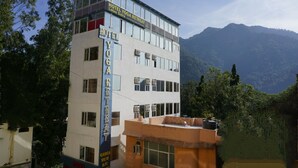 Ein mehrgeschossiges Hotel namens "Hotel Yoga Retreat" mit einem Schild, das anbietet, Lotus-Sutra-Meditationen anzubieten.