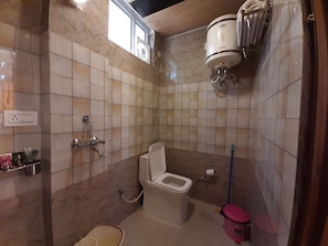 A bathroom with a toilet, a bidet, a shower, and a hand dryer.