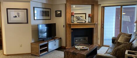 A living room with a TV, fireplace, and a sofa.