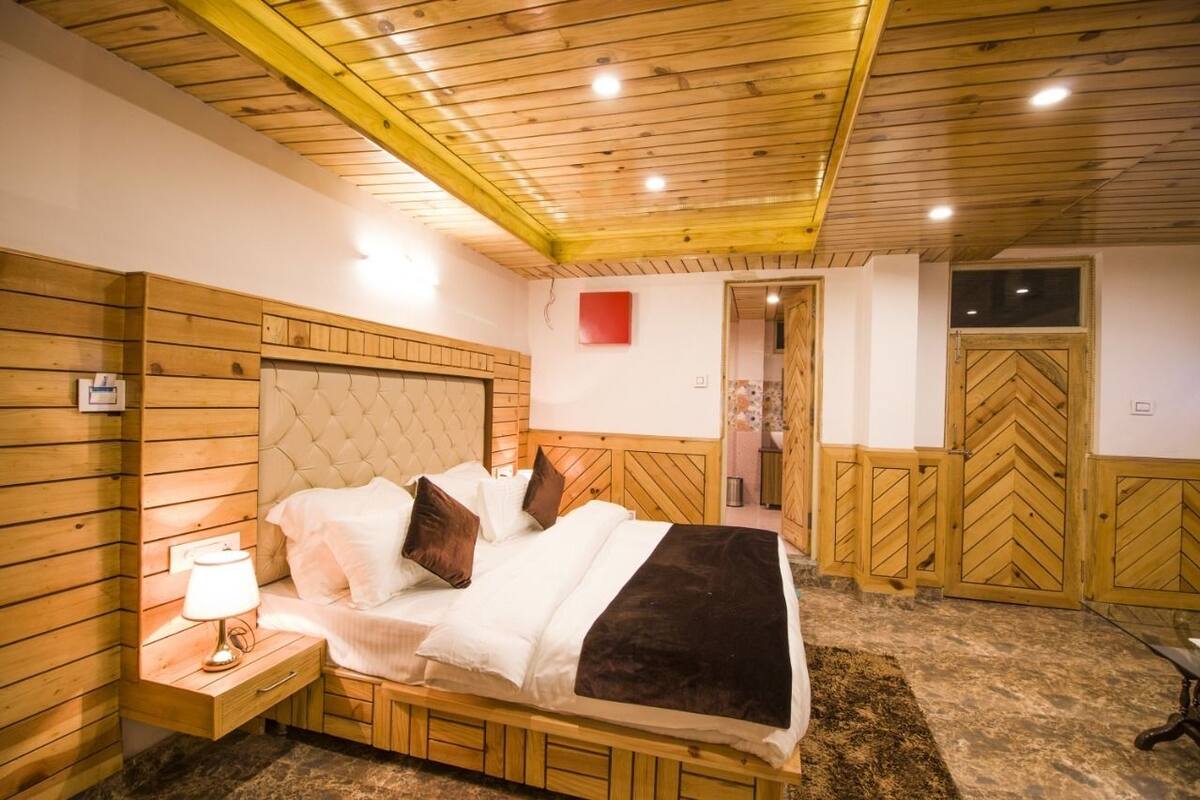 Ein Schlafzimmer mit Holzwandverkleidung, einem Bett, einem Nachttisch und einer roten Wanddekoration.