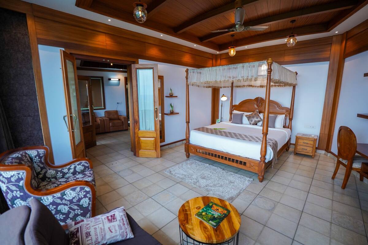 Un dormitorio espacioso con cama con dosel, techo de madera y suelo de baldosas.