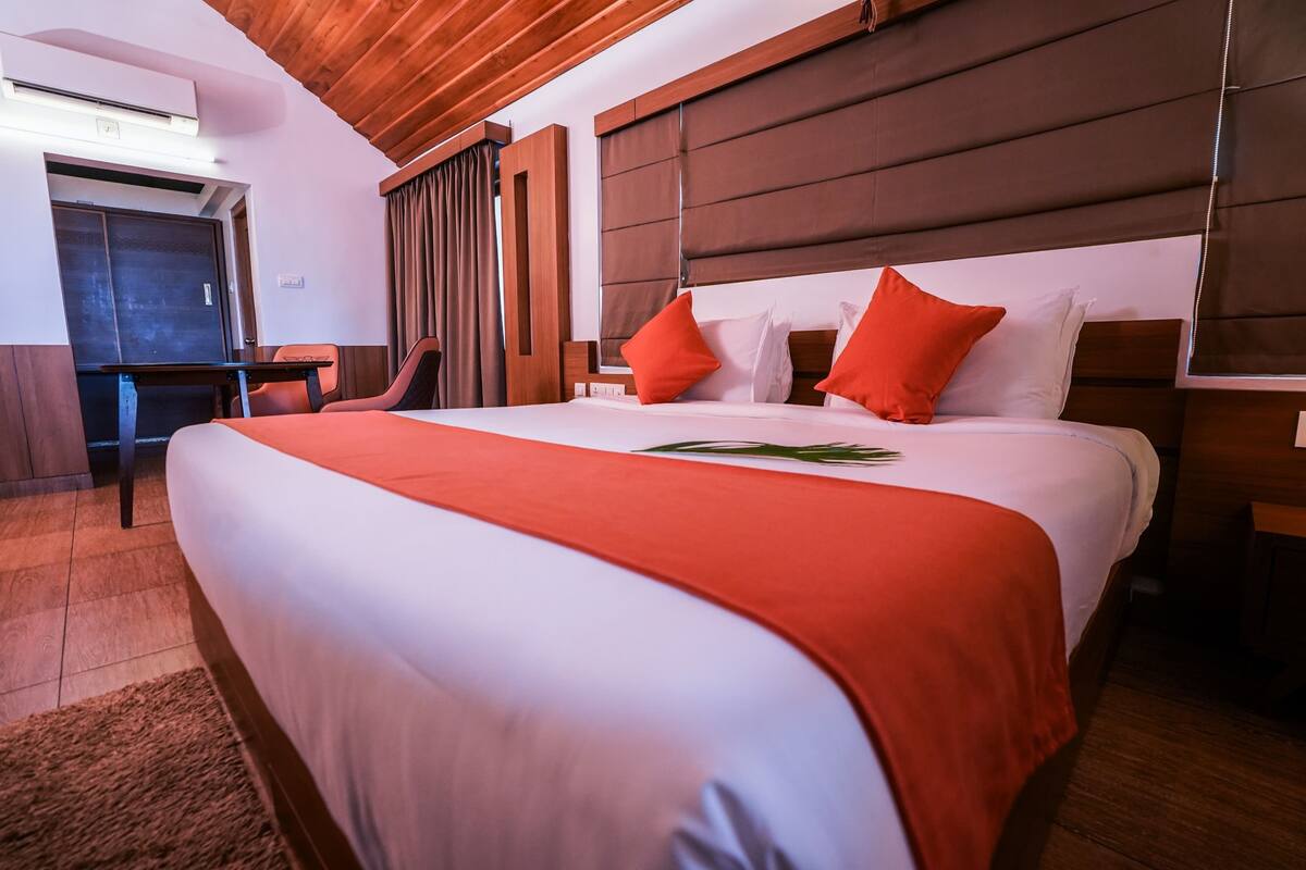 Una habitación de hotel con una cama grande, un escritorio y una silla.