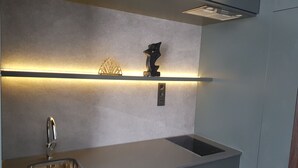 Et moderne køkken med en stålvask, indbygget ovn og en stilfuld bordplade.