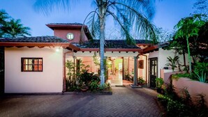 Ein Haus mit Ziegeldach, überdachter Veranda und befestigter Auffahrt.