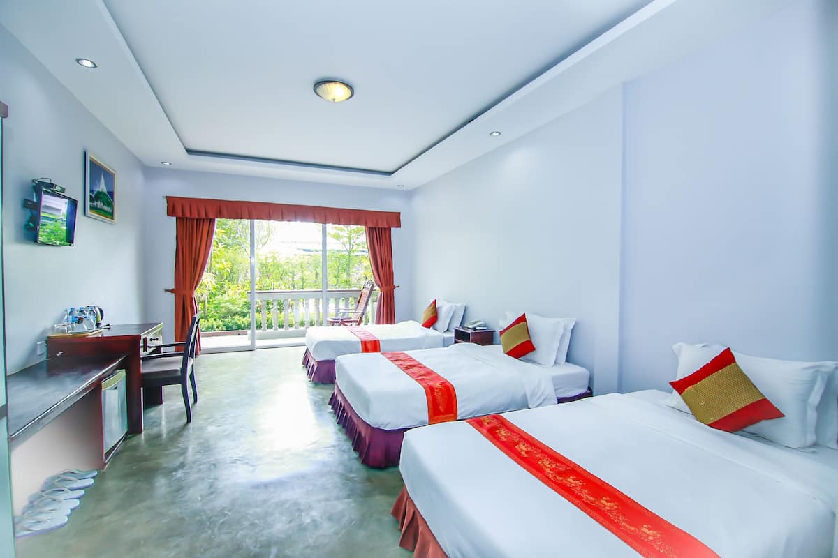 Ein Hotelzimmer mit zwei Betten, einem Schreibtisch und einem Stuhl.