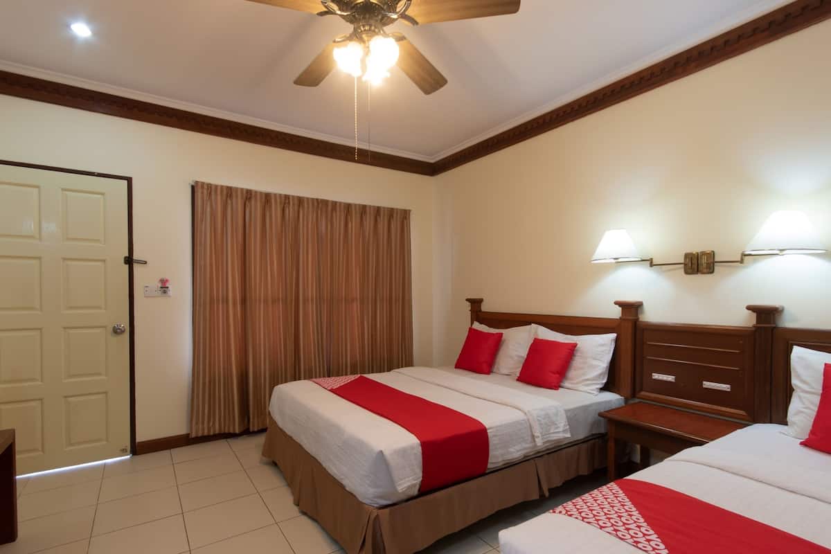 A hotel room with two beds, a ceiling fan, a door, and a curtain.