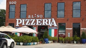 A brick building with a large sign reading "Alino Pizzeria" and "Benvenuto Welcome" on the entrance. -  Completely renovated single family home with new furnishings. (Mooresville)