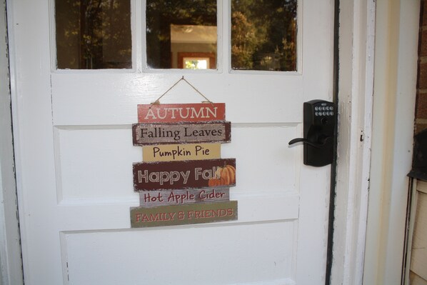 A door with a sign that reads "AUTUMN Falling Leaves Pumpkin Pie Happy Fall Hot Apple Cider FAMILY & FRIENDS." - Completely renovated single family home with new furnishings. (Mooresville)