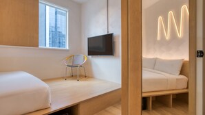 A modern room with a bed, a chair, a TV, and a neon sign. - MoMo's Kuala Lumpur (Kuala Lumpur)