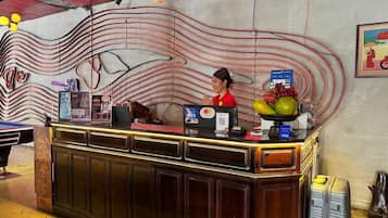 A reception desk with a digital screen, a Visa card reader, and a fruit bowl.