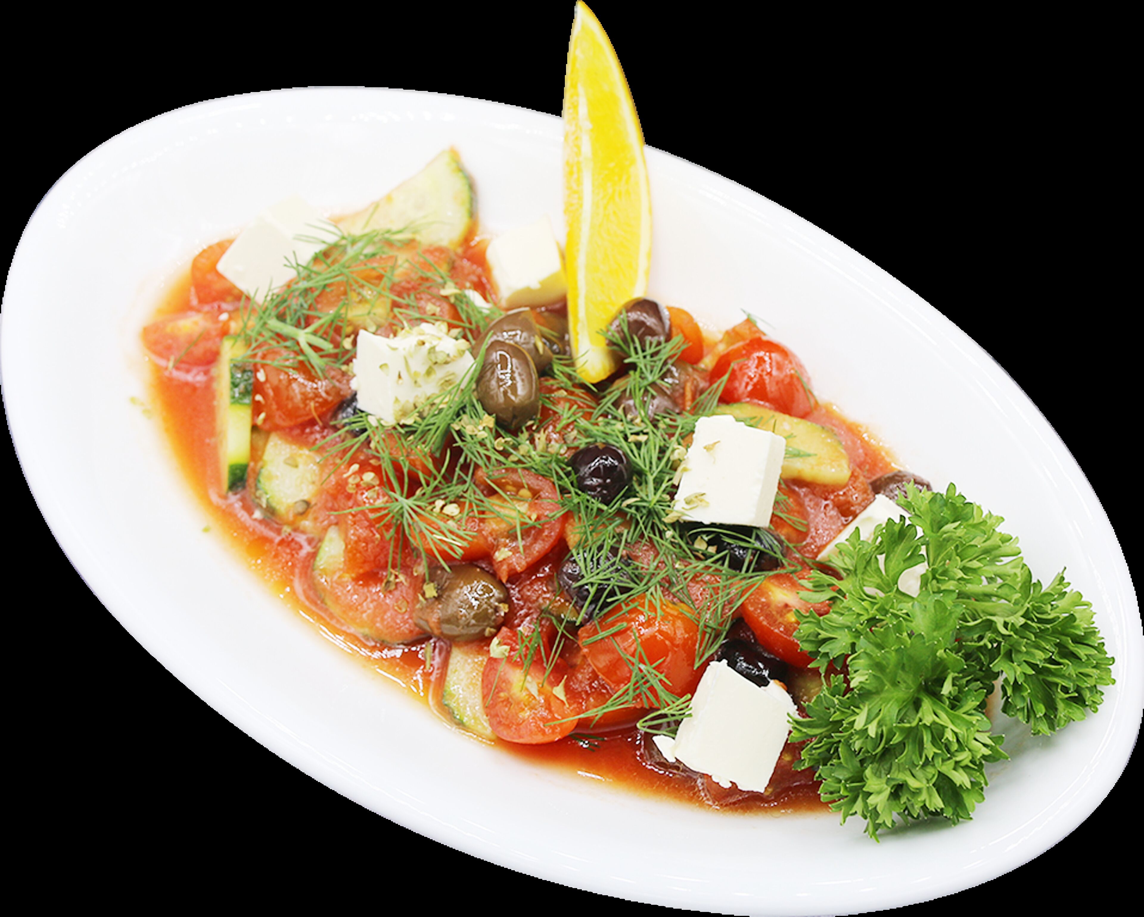 En hvid oval tallerken med en salat bestående af tomater, agurker, oliven og fetaost, pyntet med persille og et stykke citron.
