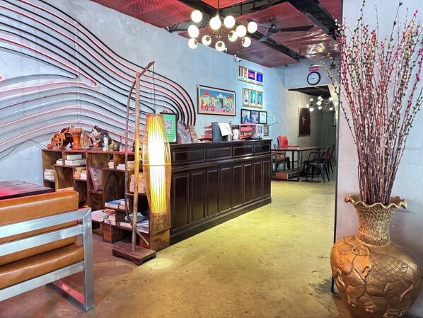 Un interior moderno con techo curvo, una zona de bar central y diversas obras de arte en las paredes.