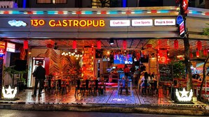 Un gastropub con terraza, un cajero automático de Canada Bank y letreros de neón.