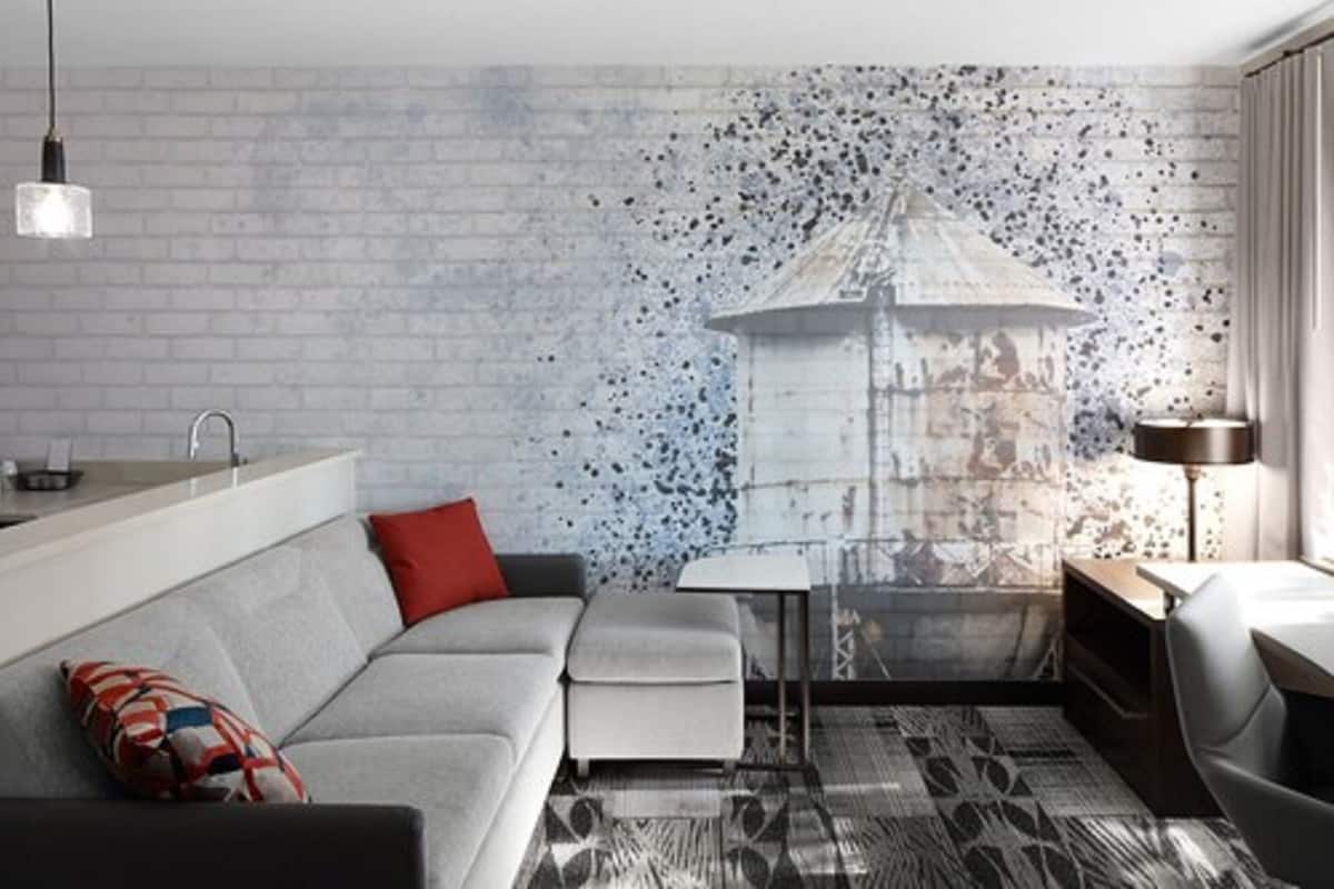 A modern living room with a grey sofa, a small table, and a lamp.