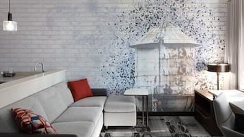 A modern living room with a grey sofa, a small table, and a lamp.