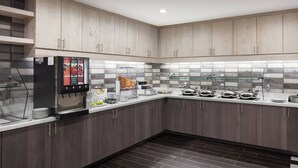 A modern kitchen with grey cabinets, a built-in refrigerator, and a glass-tiled backsplash. - Residence Inn Richmond Midtown/Glenside (Richmond)