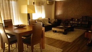 A living room with a dining table, chairs, a sofa, a coffee table, and a bookshelf. - Quiet and bright apartment. WIFI + FREE BREAKFAST (València)