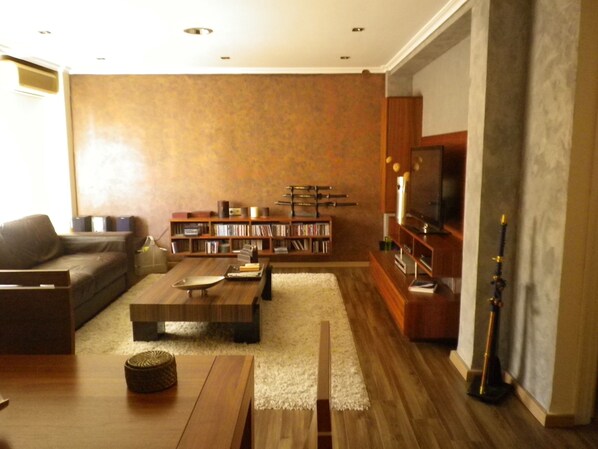 A modern living room with a sofa, coffee table, bookshelf, and a television. - Quiet and bright apartment. WIFI + FREE BREAKFAST (València)