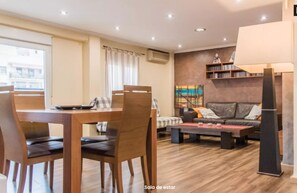 A modern living room with a dining area, a sofa set, and a bookshelf. - Quiet and bright apartment. WIFI + FREE BREAKFAST (València)