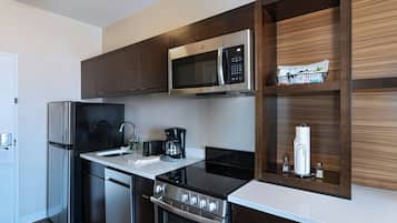 A modern kitchen with stainless steel appliances, a built-in microwave, and a coffee maker.