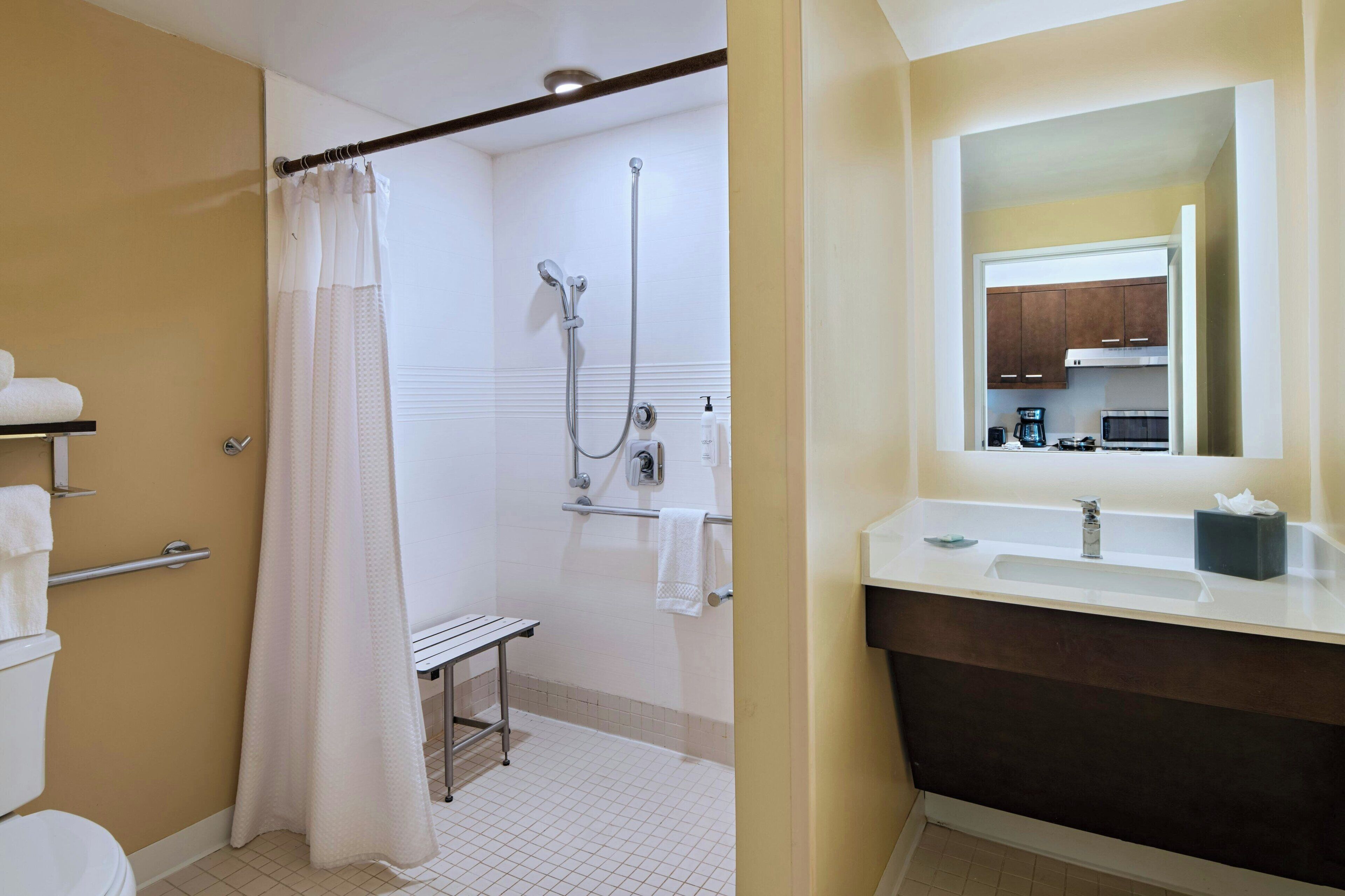 A bathroom with a shower, toilet, and sink.