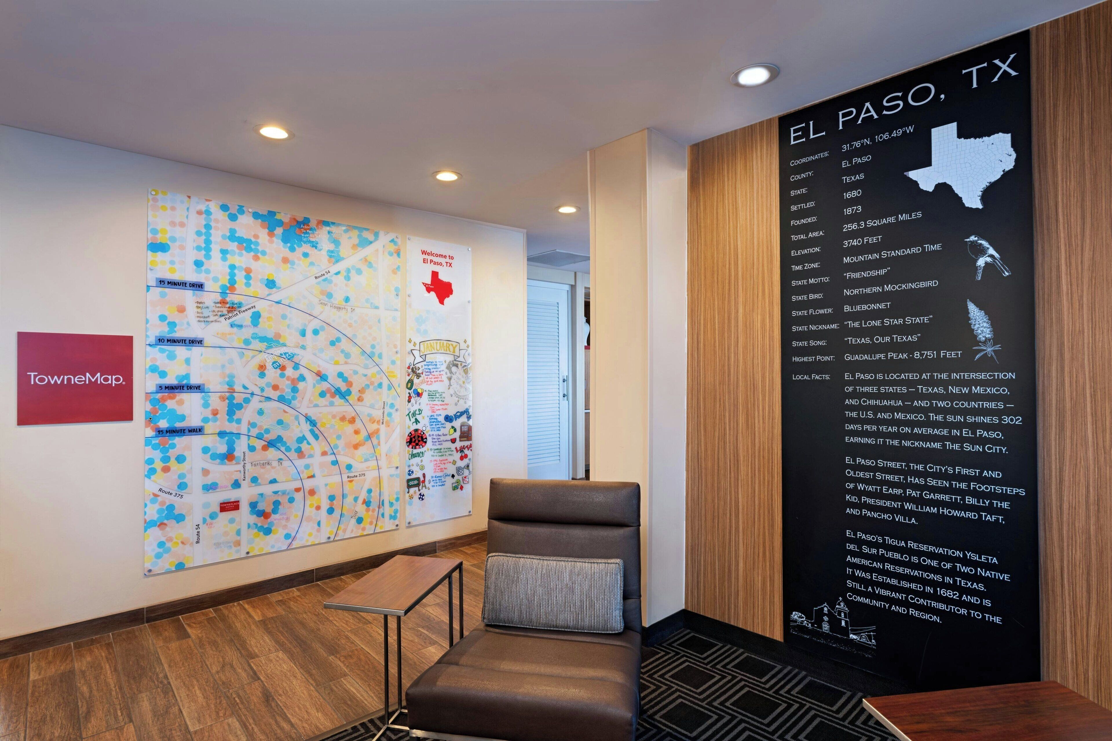 A lobby with a large map, a seating area, and a wall with information about El Paso, TX.
