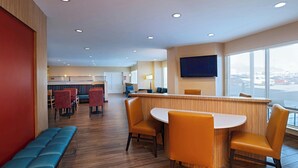A modern hotel lobby with a reception desk, seating area, and large windows offering a view. - TownePlace Suites by Marriott El Paso North (El Paso)