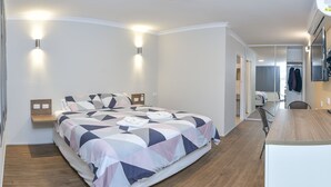 A modern bedroom with a large bed, bedside tables, and a built-in wardrobe. - Platinum Motel (Beckenham)