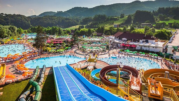 A water park with multiple pools, slides, and a large blue slide. - Duplex Penthouse Aparthotel Rosa (Podcetrtek)