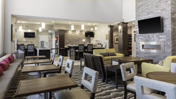 En moderne hotellobby med bar, siddeområde og pejs.