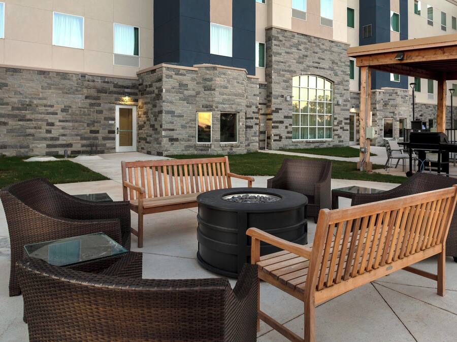 An outdoor seating area with wicker furniture and a fire pit.