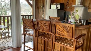 Un interno in legno con zona bar, sedie di legno e un tavolo da pranzo.