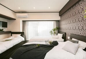 A modern hotel room with two beds, a large window with curtains, an air conditioning unit, and a patterned wall. - Vacation Rent Kanayama (Nagoya)
