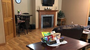 Ein Essbereich mit Holztisch, Stühlen und einem Fernseher über einem Kamin.