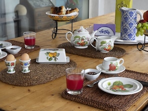 A breakfast setting with a wooden table, tea set, eggs, and a bowl of fruit. - Artevilla Relais (Massa Lubrense)