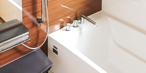 Un baño moderno con una bañera blanca, grifería cromada y un mueble de tocador de madera.