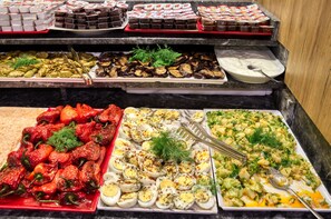 A buffet with various dishes including roasted peppers, eggs, and a variety of other prepared foods. - Istanbul Sirkeci Otel (Istanbul)