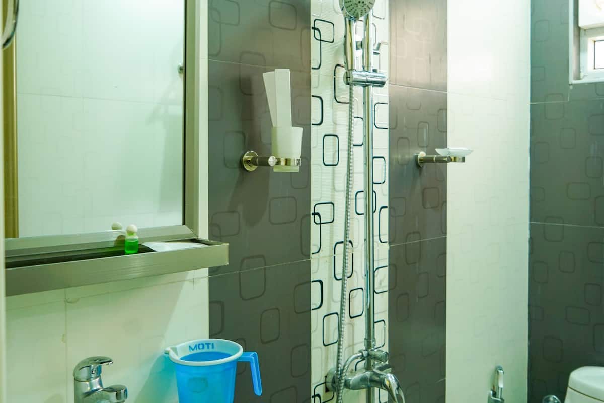 Een badkamer met een wastafel, spiegel, douche en toilet.