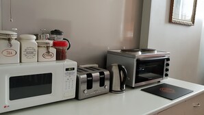 Una kitchenette equipada con microondas LG, tostadora, cafetera y horno tostador.