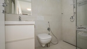 Ein modernes Badezimmer mit Toilette, Waschbecken und Dusche.