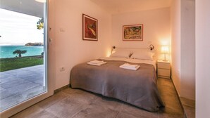 Ein Schlafzimmer mit einem Bett, zwei Wandlampen und zwei gerahmten Bildern.
