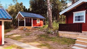 A cabin with a porch, a small deck, and a wooden staircase leading to the entrance.