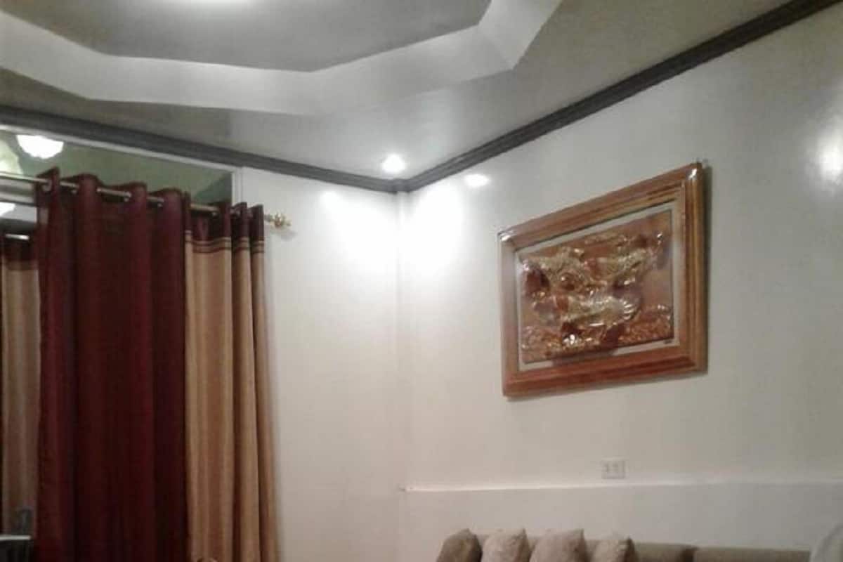 Ein Schlafzimmer mit einem hölzernen Bett, einer Couch, einem kleinen Tisch und einem gerahmten Bild an der Wand.