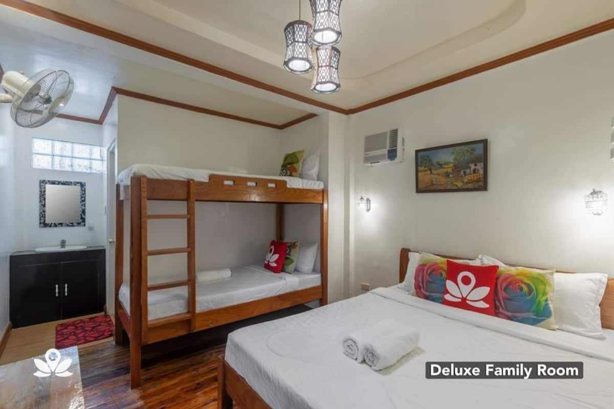 Familienzimmer Deluxe mit Etagenbett, Nachttisch, Spiegel, Waschbecken und Fenster.