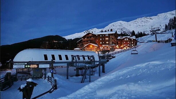 Ein schneebedecktes Skigebiet mit einer großen Lodge und einer Seilbahn.
