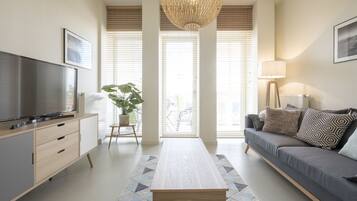 Appartement Deluxe | Salle de séjour | Télévision à écran plat de 100 cm avec chaînes numériques, télévision