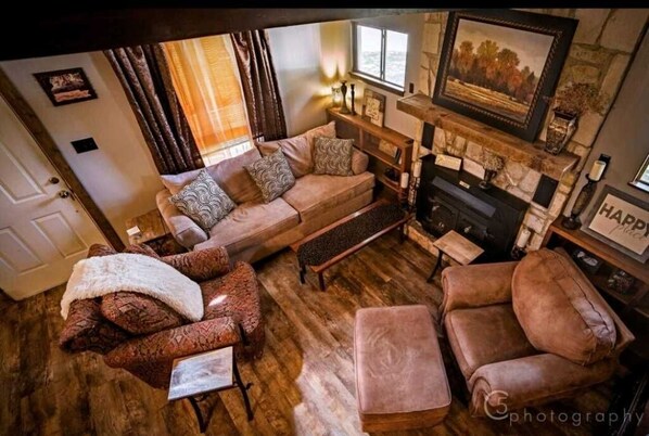 Un salon chaleureux avec un canapé, des fauteuils et une cheminée.