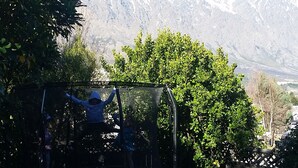 Ein Trampolin in einem Garten mit Blick auf die Berge.