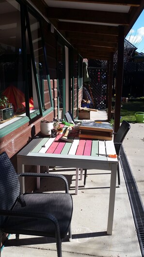 Relax on the patio surrounded by lush greenery and a serene garden view.
