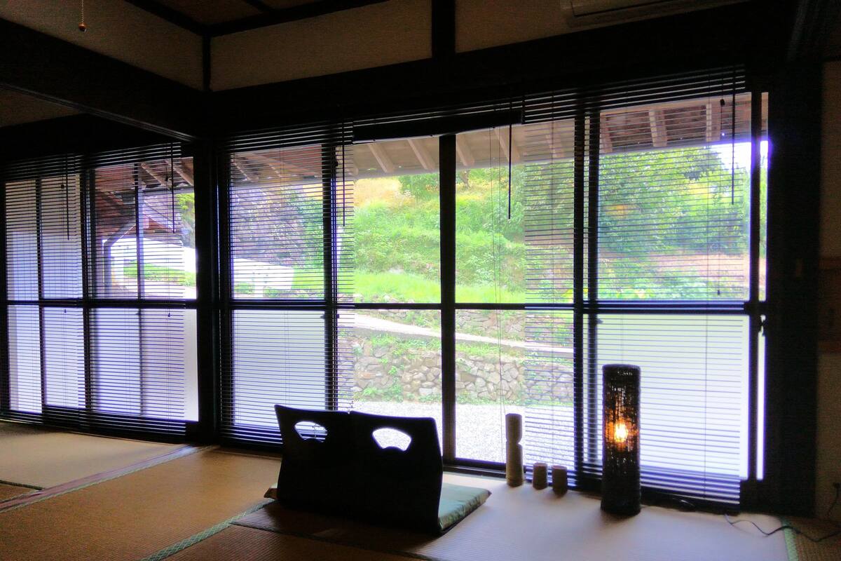 A tatami mat room with a tatami mat sofa, a small table, and a candle.